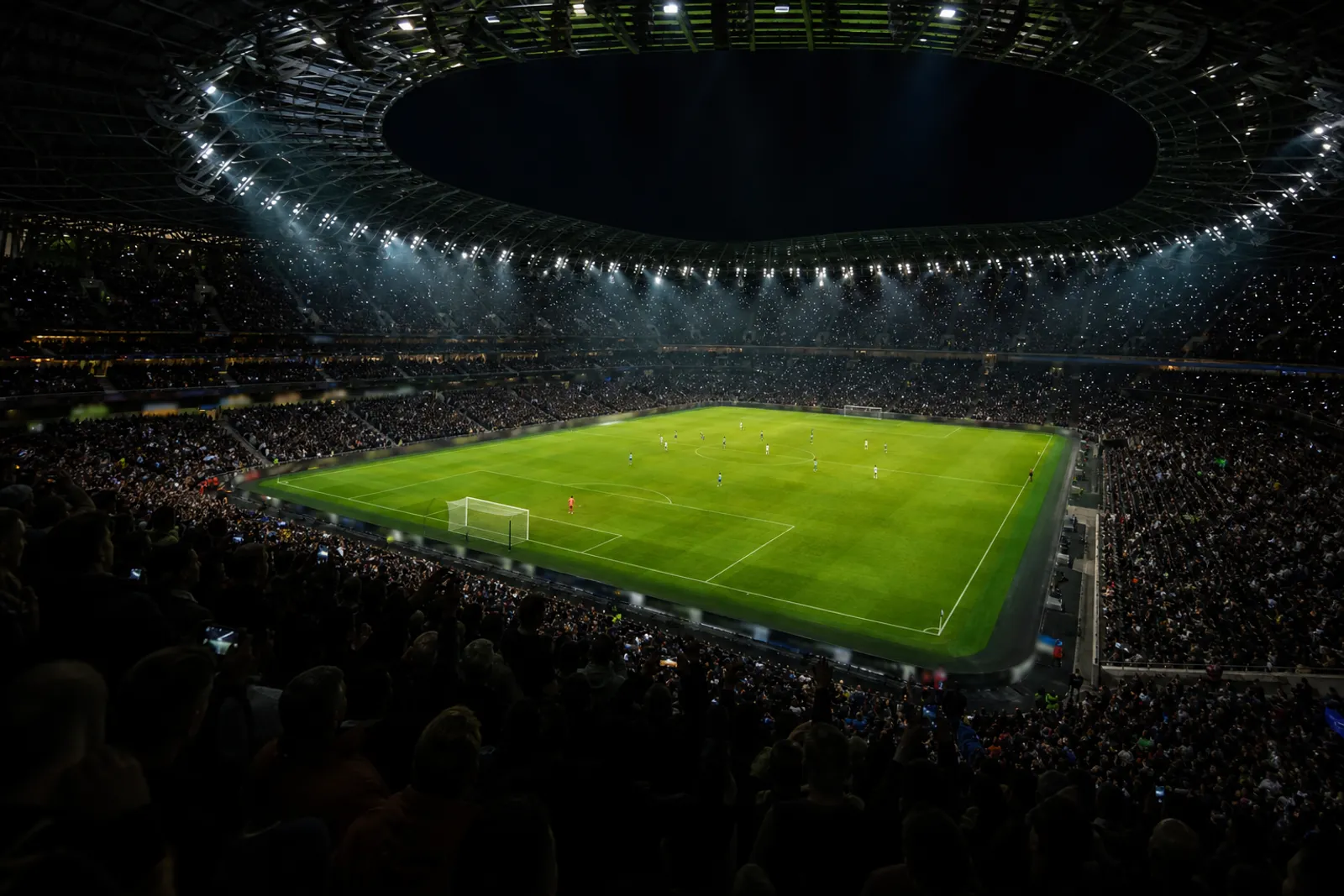 Packed football stadium at night under floodlights during a live match, streamed in HD on IPTV